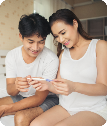 a man and woman looking at a pregnancy test